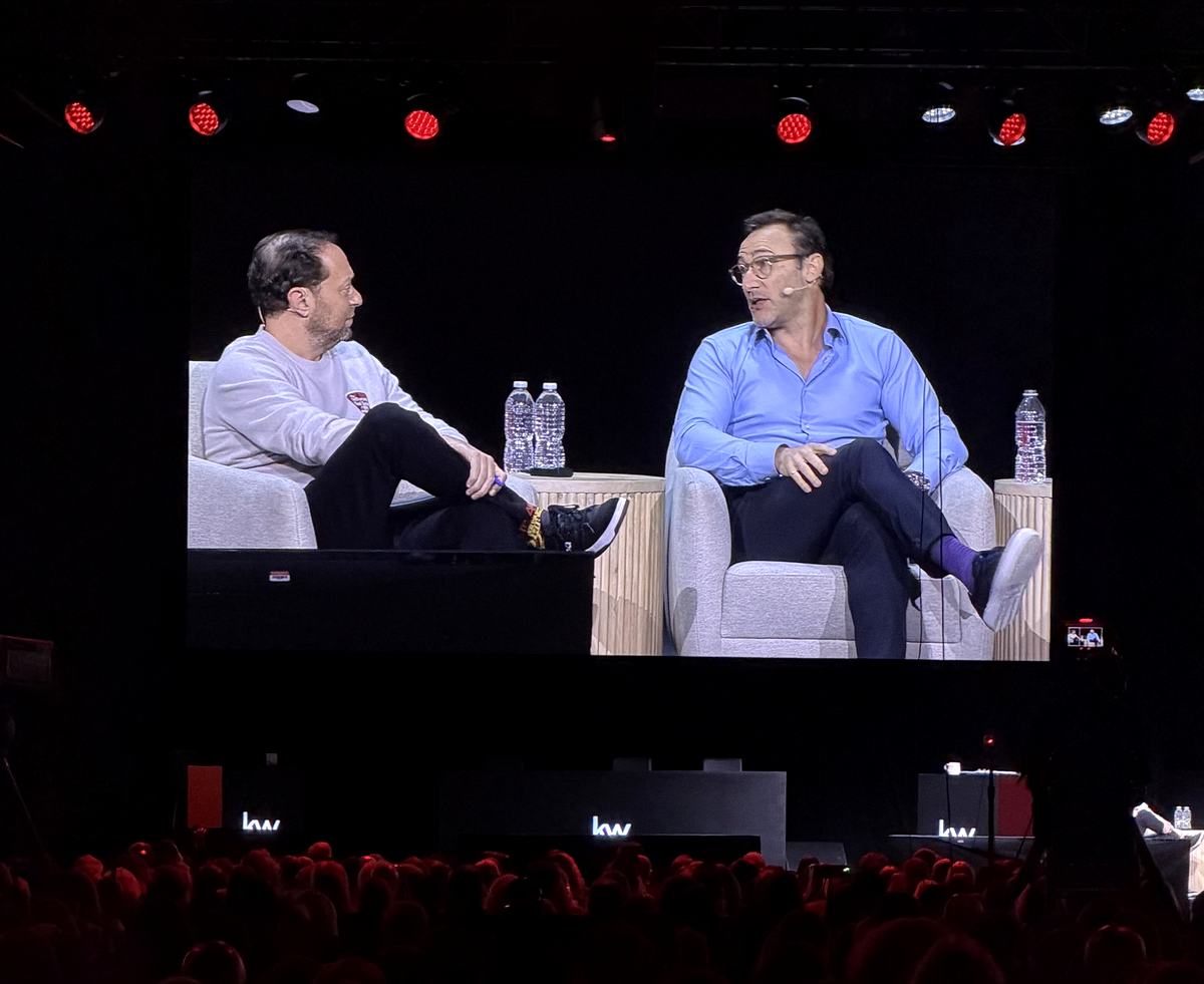 Simon Sinek in conversation with Jason Abrams on screen above the Mega Camp audience